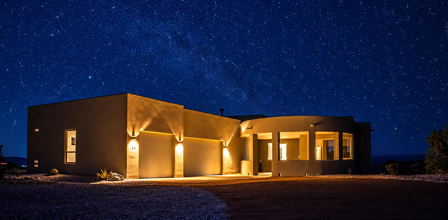 The warm-lit Cielo home beneath a star-filled New Mexico night sky