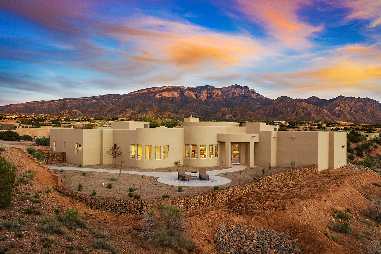 An Enchanted Spaces Southwestern-style home beneath the Sandia Mountains at sunset